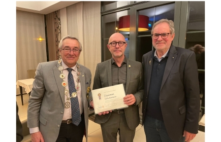 Pit Duschinger avec son certificat PHS entouré par le gouverneur et le coordinateur au Luxembourg.